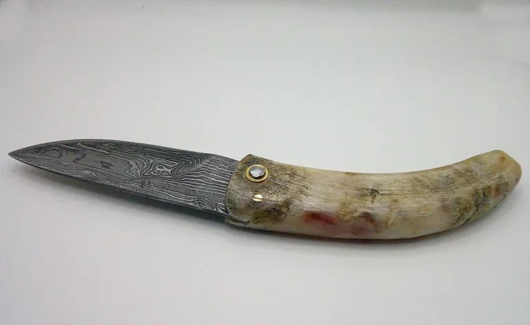 Curnichjiolu Padovani ouvert, vue arrière du manche et de la lame damas couteau-corse-padovani-corne-belier-damas-carbone-ouvert-arriere.webp