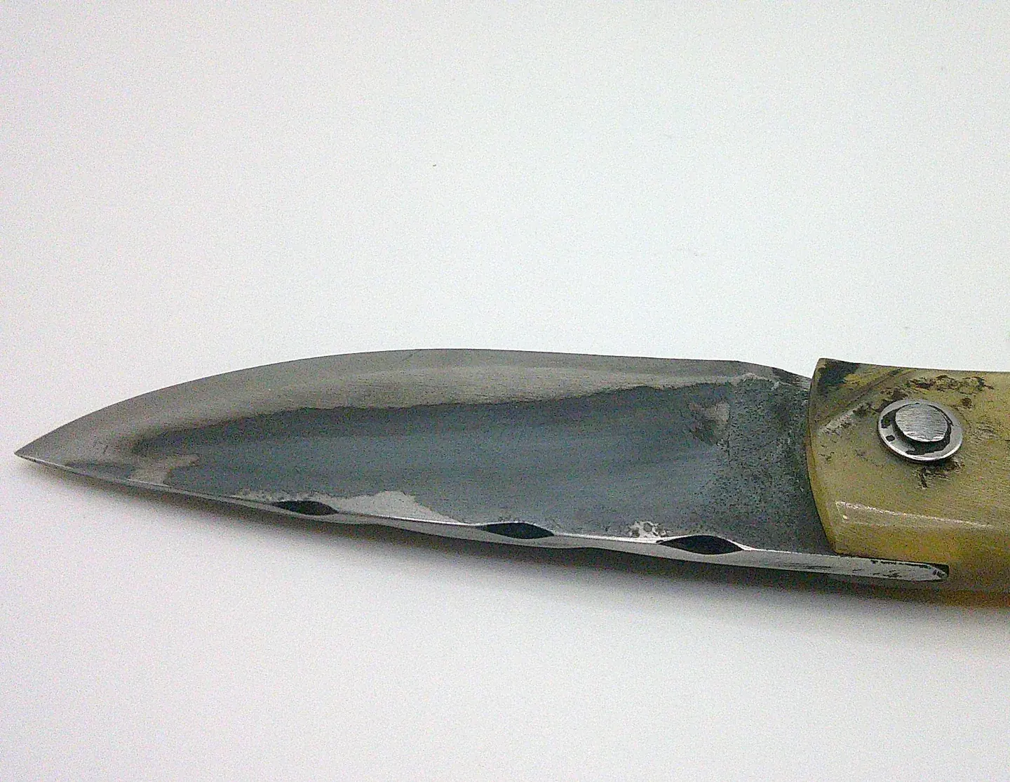 Détail de la lame en acier carbone XC75 du couteau corse artisanal Curnichjiolu Manu Padovani, avec traces de trempe visibles.