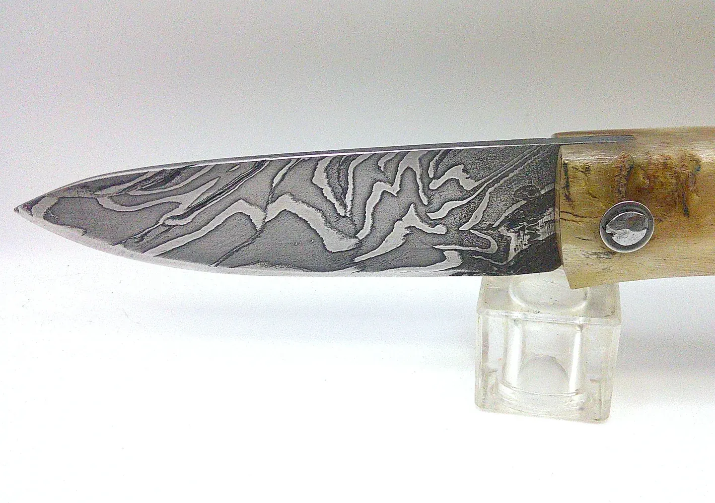 Détail de la lame en acier damas carbone du Curnichjiolu Padovani, motifs contrastés et manche en corne de bélier blonde.