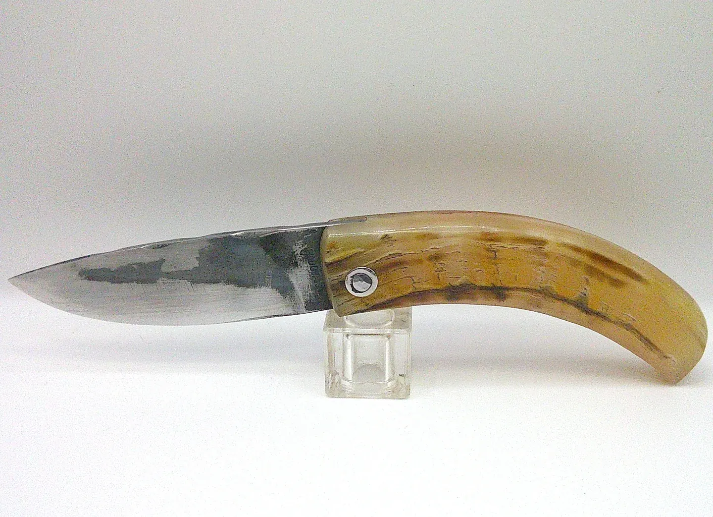Couteau corse pliant Curnichjiolu Manu Padovani ouvert, lame carbone XC75 orientée à gauche et manche en corne de bélier flammée.