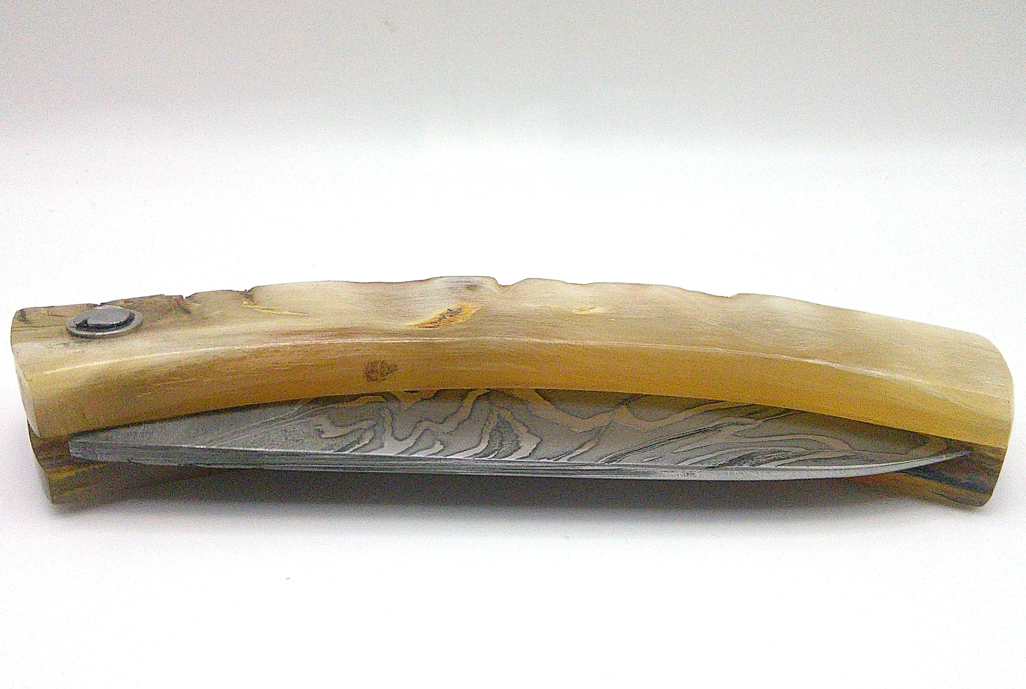 Couteau corse pliant Curnichjiolu Padovani fermé, vue latérale du manche blond naturel avec lame en damas carbone repliée.