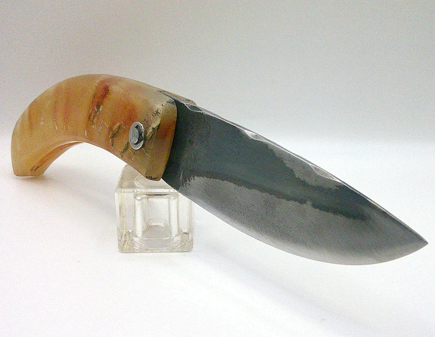 Curnichjiolu artisanal Manu Padovani ouvert en vue trois quarts droite, lame XC75 avec finition brute de forge et manche recourbé en corne flammée.